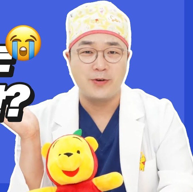 수술모자와 의사 가운을 입고 푸 인형을 든 의사