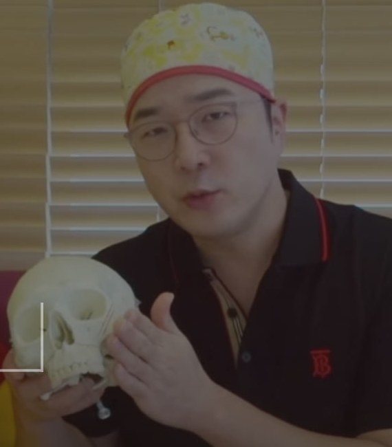 두개골 모형을 들고 설명하는 의사