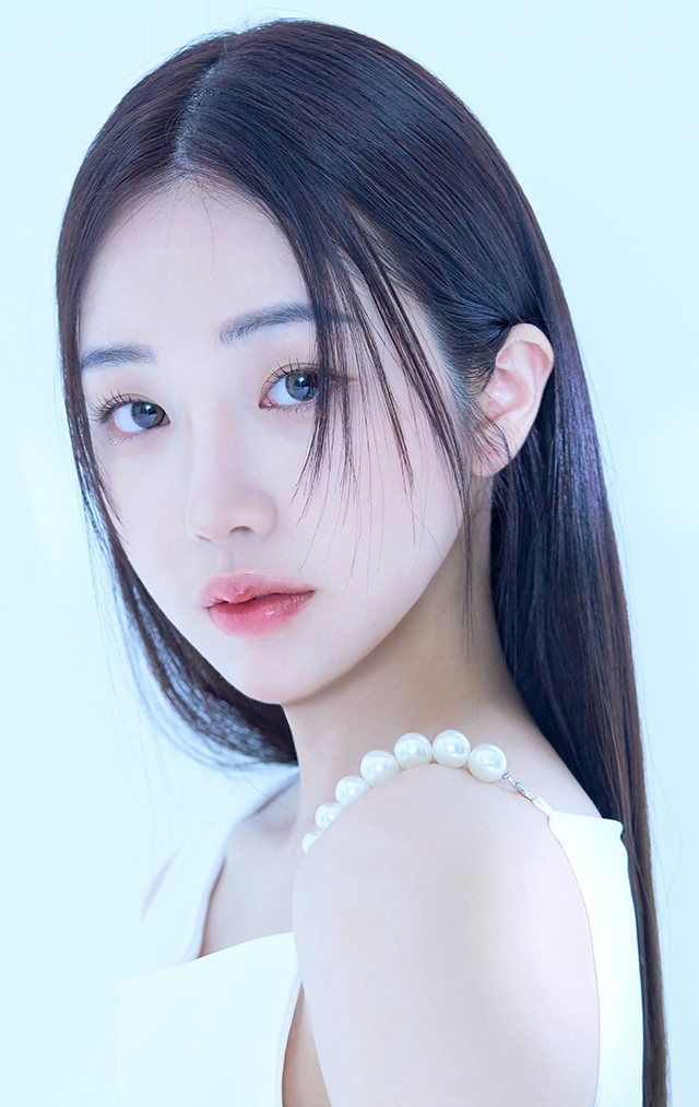 하늘빛 배경, 긴 흑발에 진주 장식 흰 옷을 입은 여성 모델