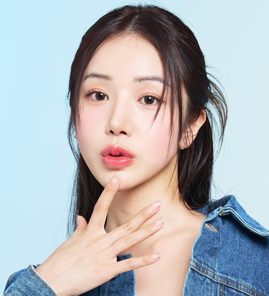 하늘색 배경, 데님 재킷을 입고 턱에 손가락을 댄 여성 모델