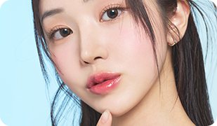 하늘색 배경, 턱에 손끝을 댄 여성 모델
