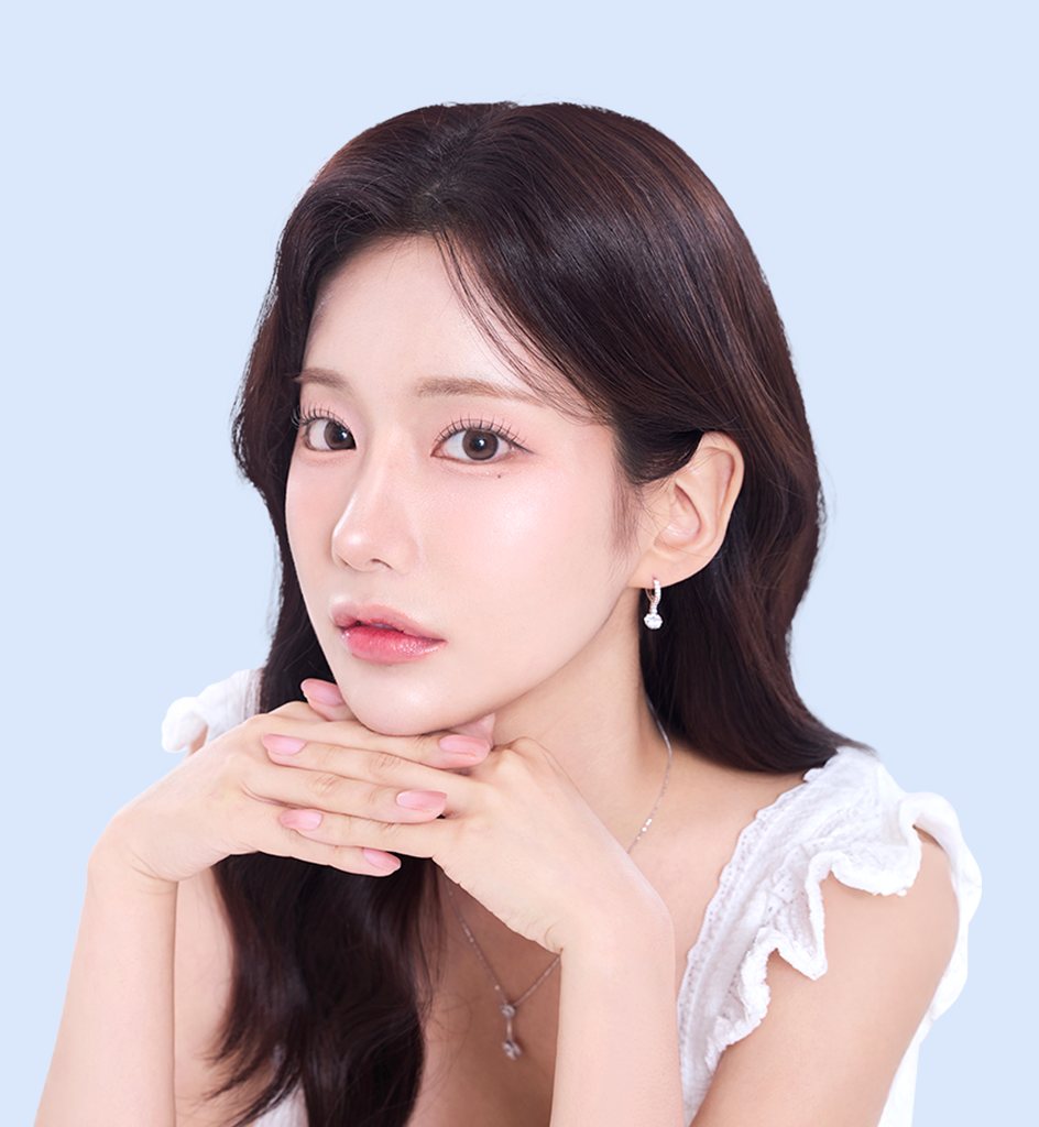 노교정 양악수술 대표 모델 — 두 손을 턱 아래에 모은 긴 흑발 여성(하늘색 배경)