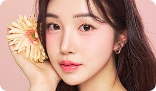 분홍 배경, 거베라 꽃을 얼굴 옆에 든 여성 모델