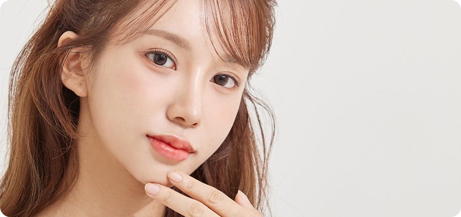 턱에 손끝을 댄 앞머리 갈색 머리 여성 모델 클로즈업