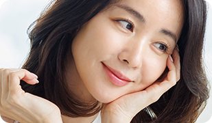 손으로 턱을 괴고 미소 짓는 여성 모델