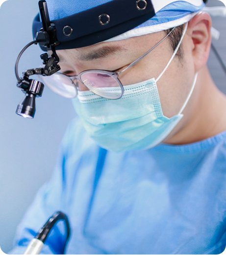 수술 루페를 쓰고 마스크를 한 집도의