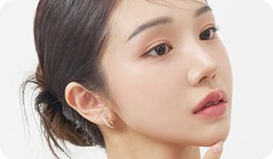 머리를 묶고 턱에 손을 댄 여성 모델의 45도 얼굴