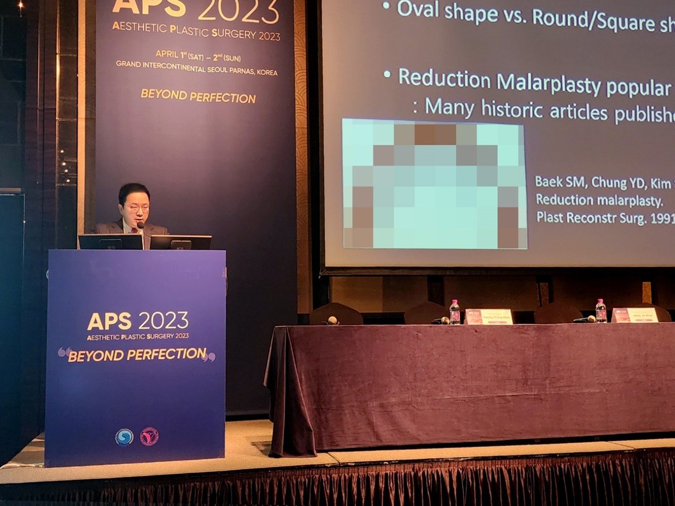 발표 장면 — 'Reduction Malarplasty popular : Many historic articles published' 슬라이드