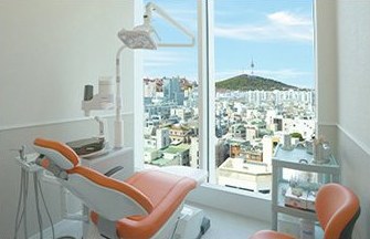 일퍼센트 둘러보기 — 창밖 도심 전망이 보이는 주황색 진료 의자 처치실