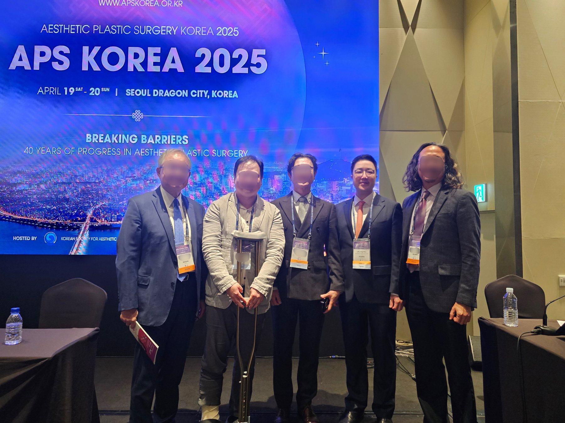 APS KOREA 2025 무대 앞 의료진 단체 사진(다른 의료진 얼굴 흐림 처리)