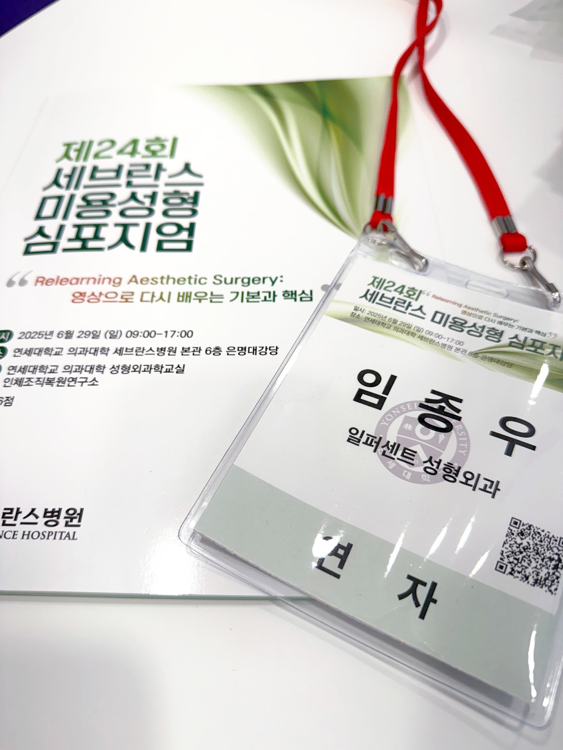 심포지엄 자료집과 ‘임종우 일퍼센트 성형외과 연자’ 명찰